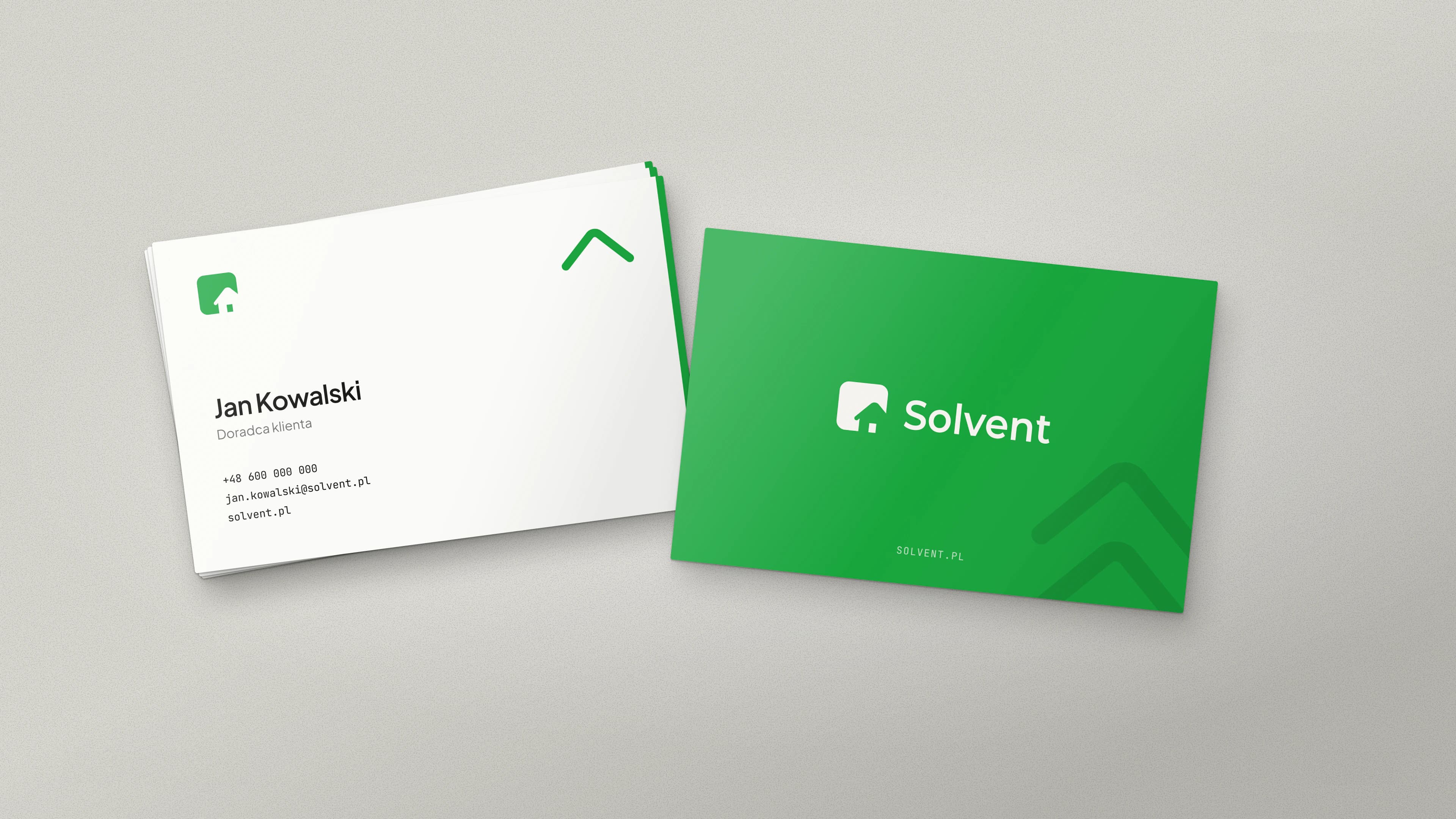 Two Solvent business cards: a white one with a name, job title and contact details, and a green one with a white logo and a chevron pattern